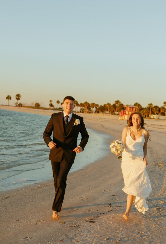bride and groom running along the beach shore in central florida