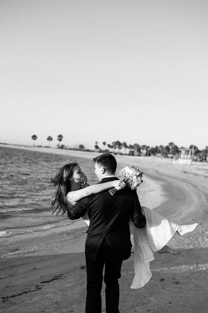 bride and groom running along the beach shore in central florida