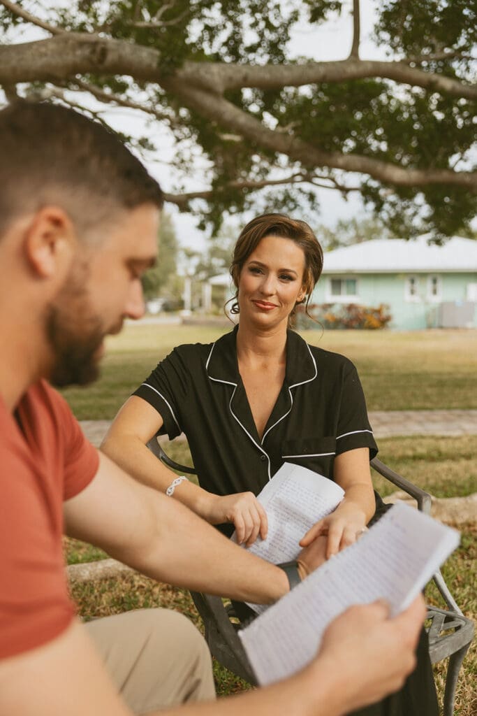 bride and groom sitting down and exchanging private vows outdoors
