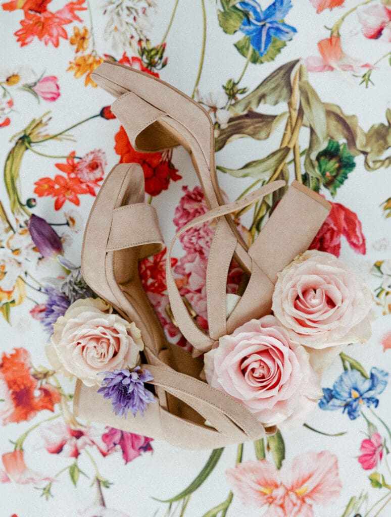 wedding detail flatlay of loose florals and shoes