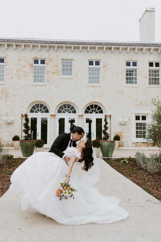 bride and groom in front of the bella cosa wedding venue