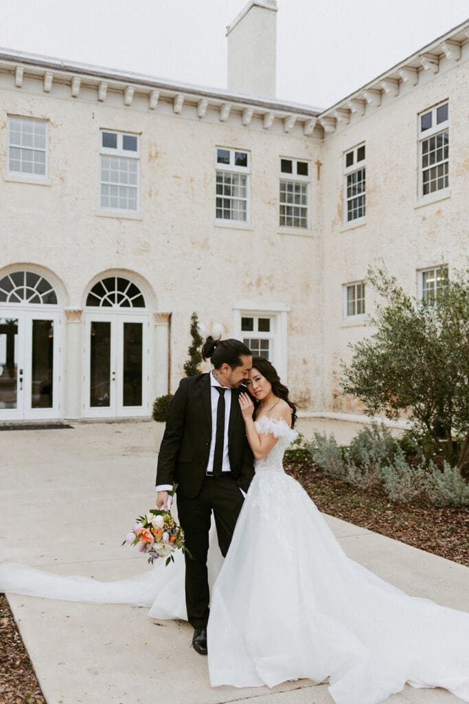 bride and groom in front of the bella cosa wedding venue