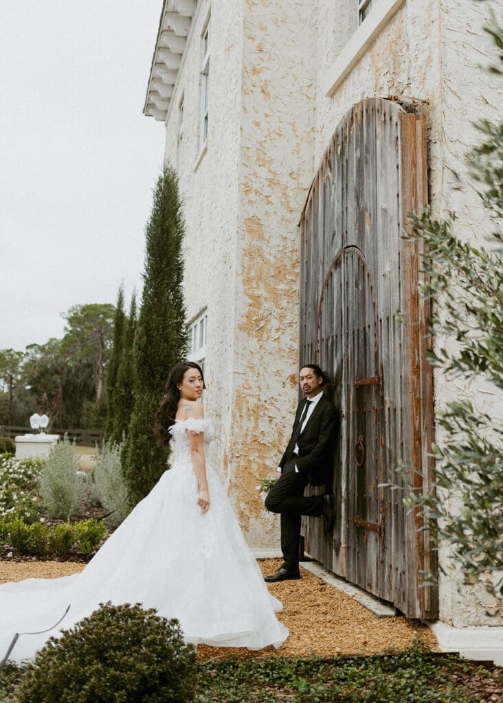 bride and groom in front of a rustic wooden door