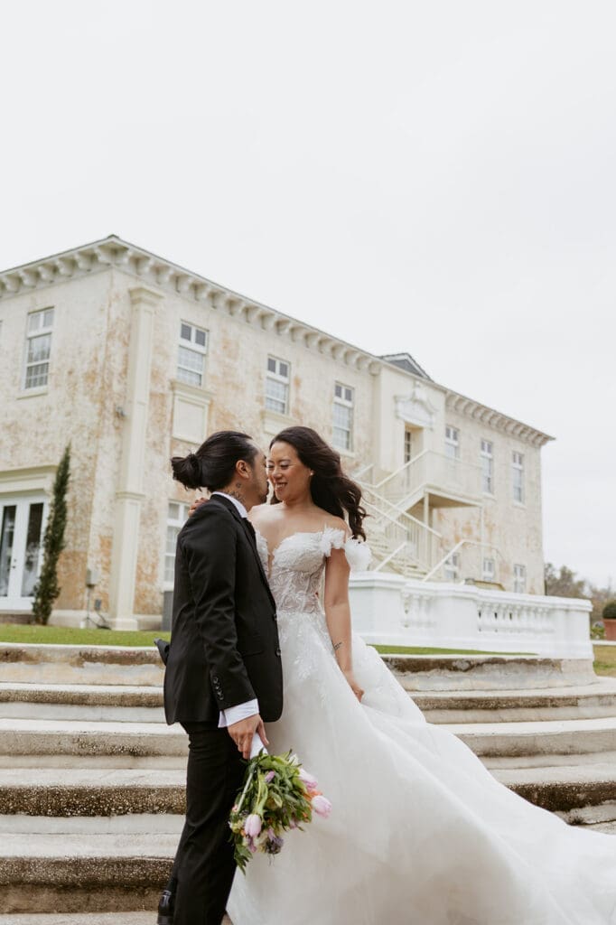 bride and groom in front of the bella cosa wedding venue