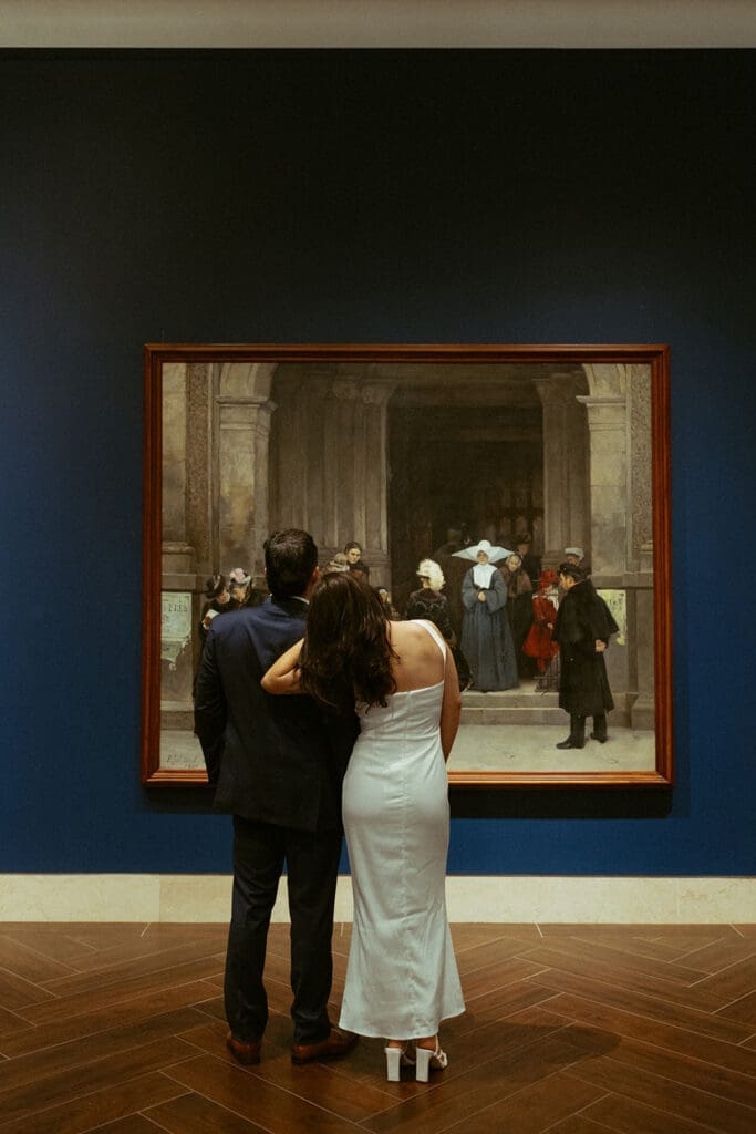 elegant couple gazing at art during their engagement photos at the Museum of fine arts