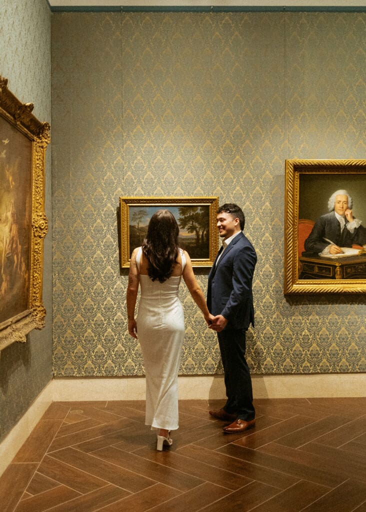 elegant couple gazing at art during their engagement photos at the Museum of fine arts