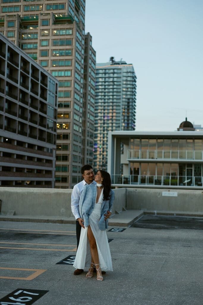 couple dancing into the night with city skyline in the background on a garage rooftop in st pete florida