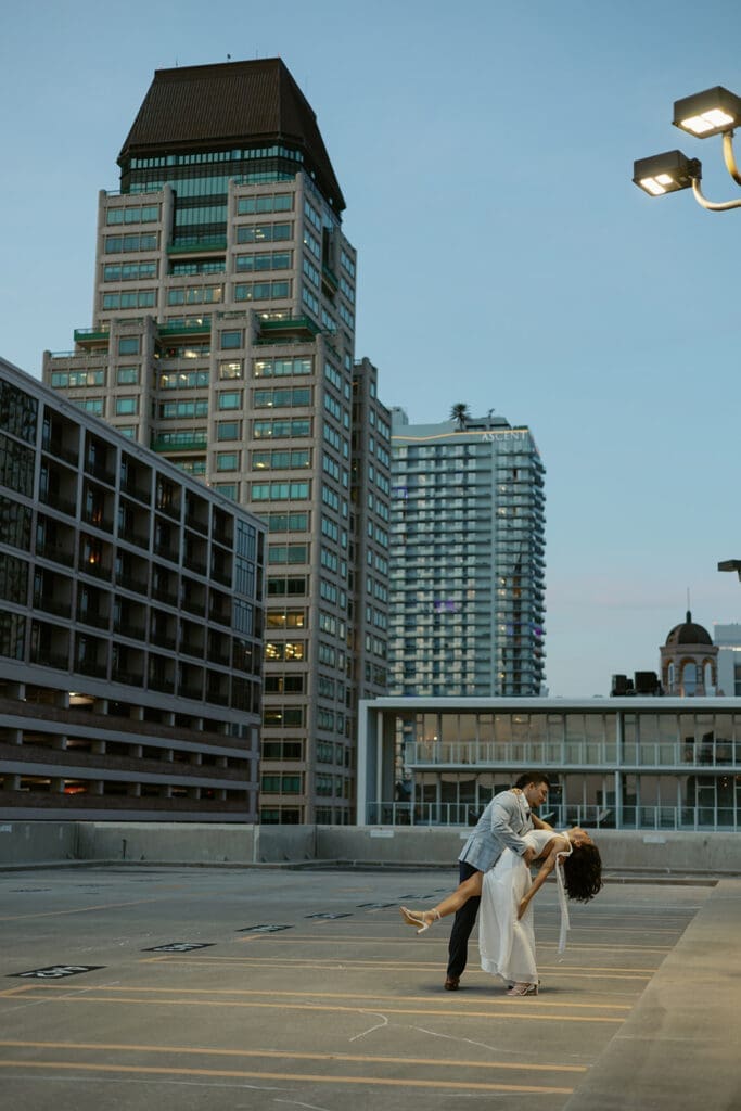 couple dancing into the night with city skyline in the background on a garage rooftop in st pete florida