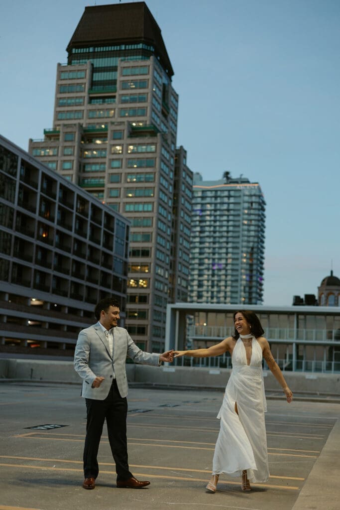 couple dancing into the night with city skyline in the background on a garage rooftop in st pete florida