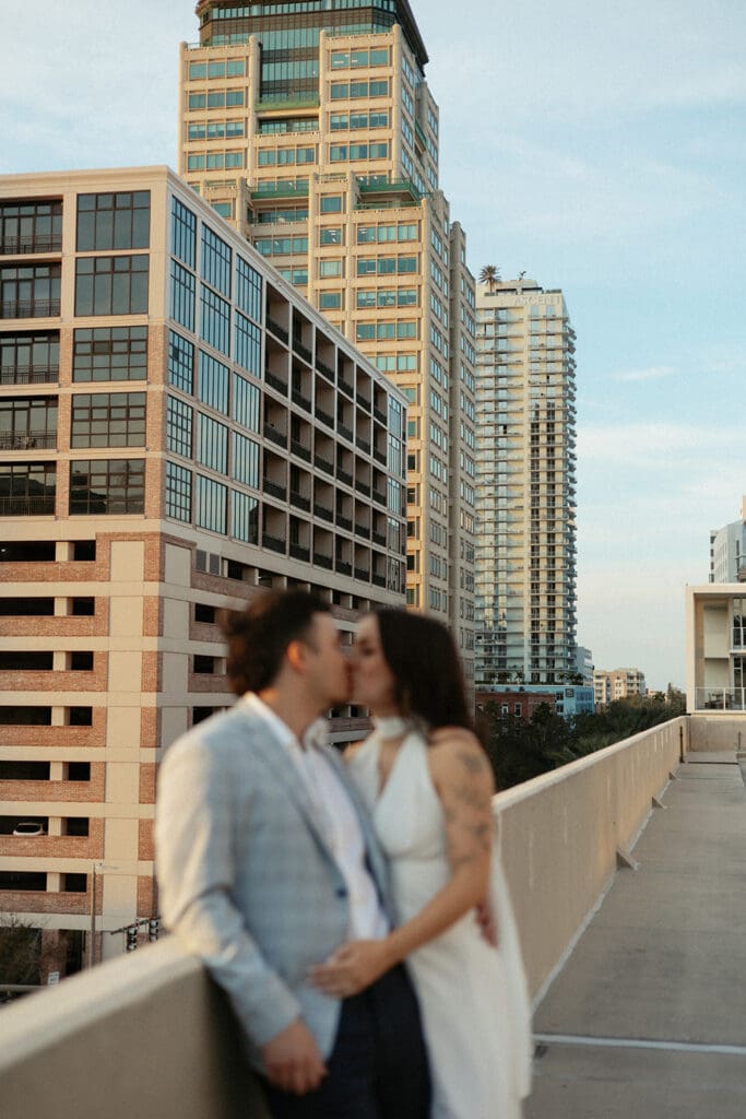 couple kissing with city skyline in the background on a garage rooftop in st pete florida
