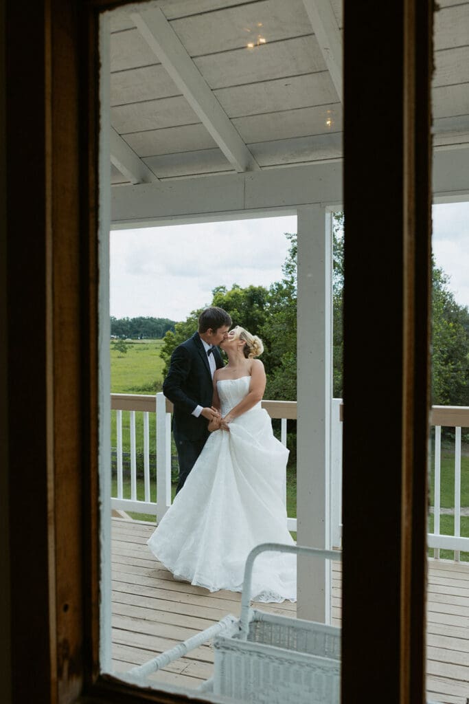 bride and groom kissing on the balcony at uliana estate