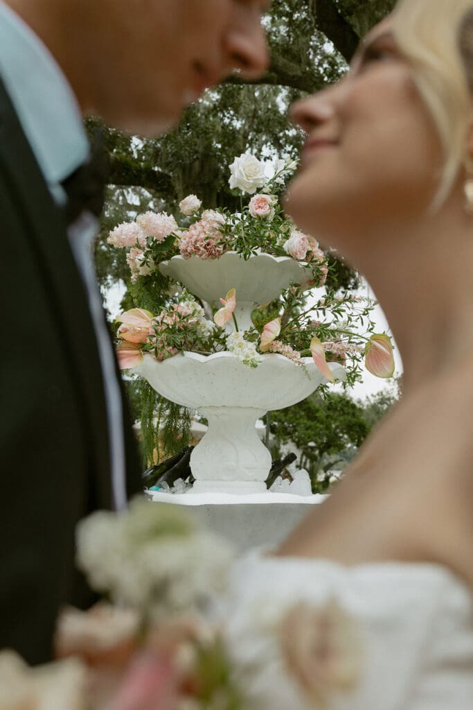 bride and groom in front of an elegant fountain area at uliana estate