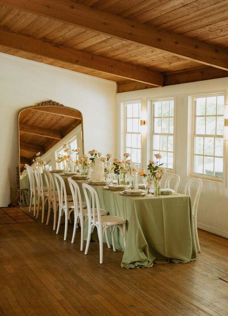 uliana estate indoor reception space, tables decorated with green linens and elegant florals
